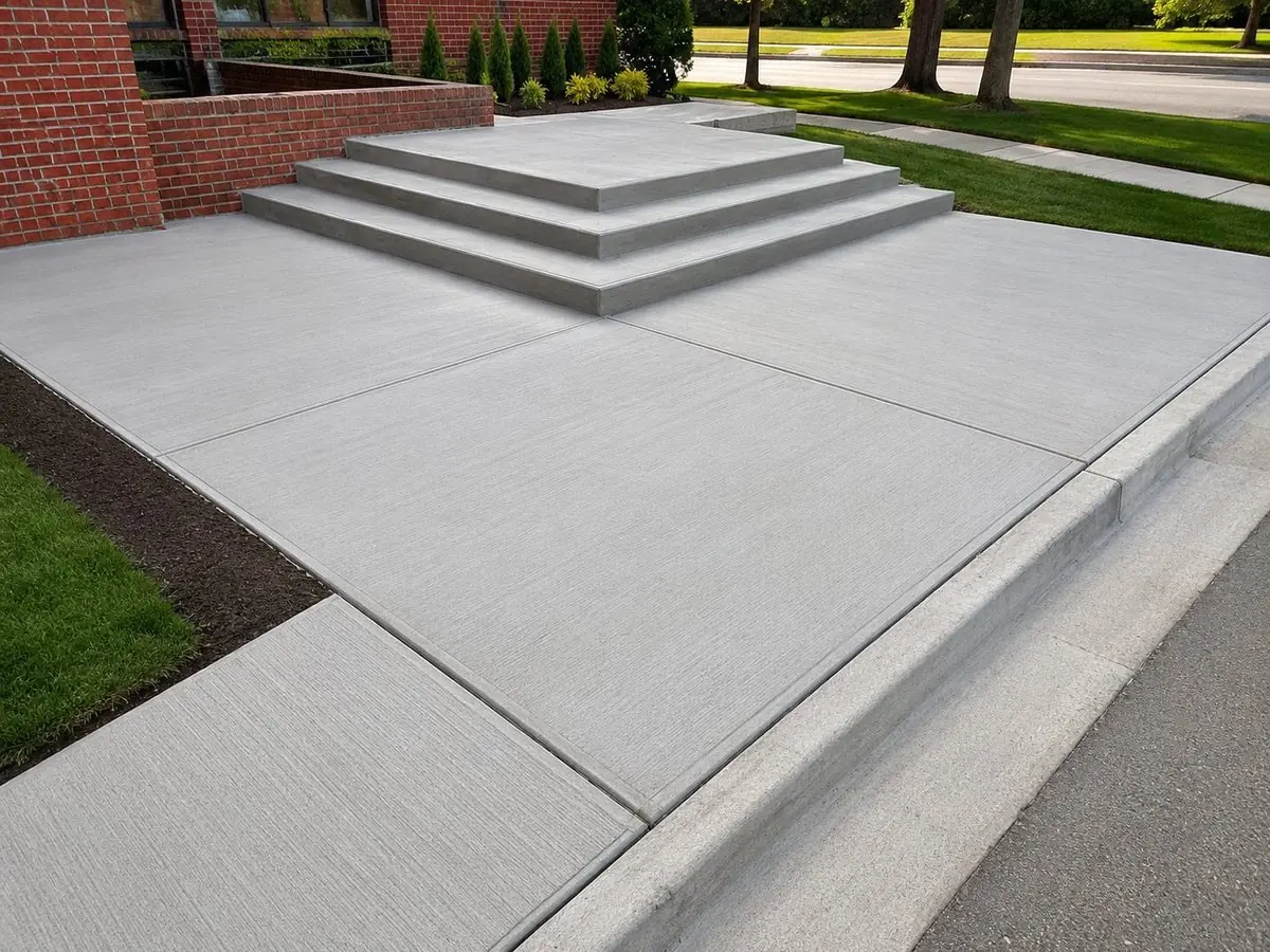 Broom-finish concrete porch and front steps on a brick home