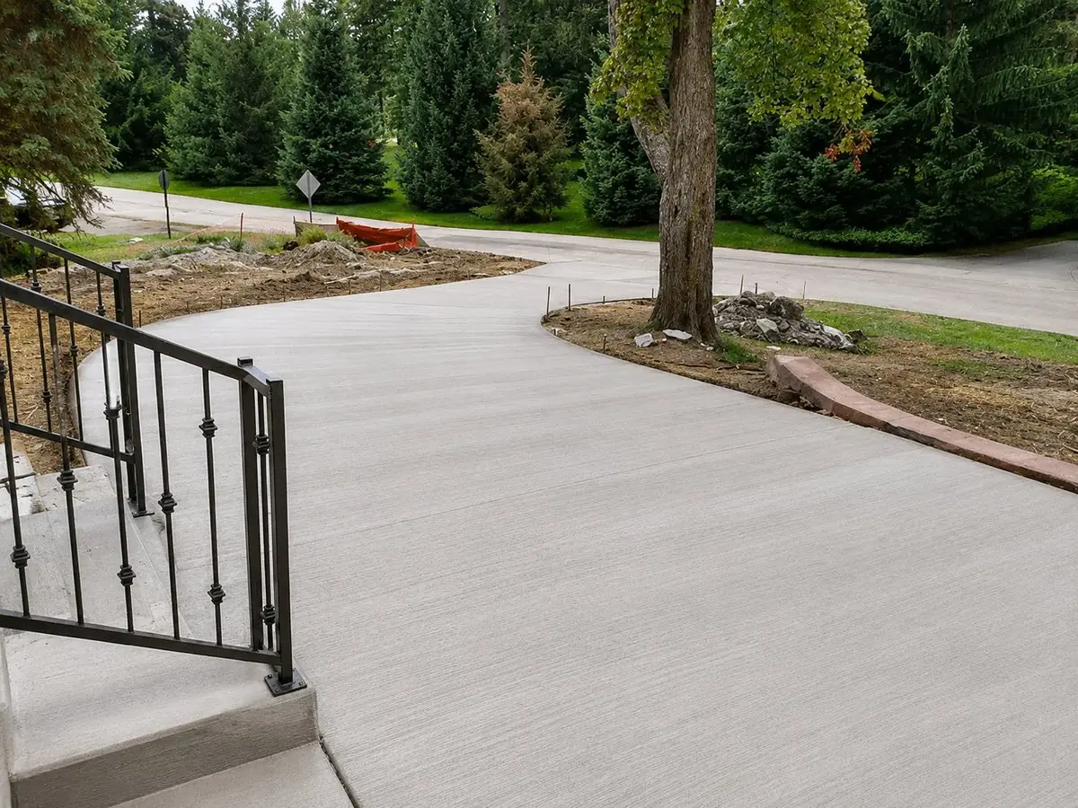Curved broom finish concrete driveway with iron railing