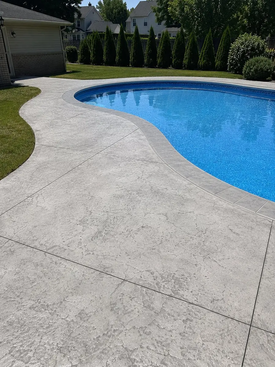Stamped concrete pool deck with curved border in Canton, MI